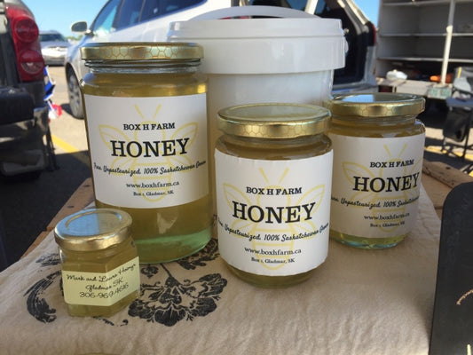 Jars and pail of liquid honey from Box H Farm